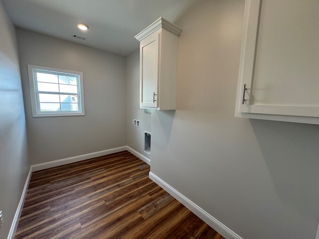 washroom featuring cabinet space, visible vents, baseboards, dark wood finished floors, and washer hookup