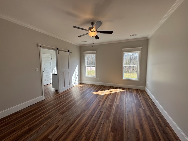 empty room with dark wood-style flooring, visible vents, crown molding, and baseboards