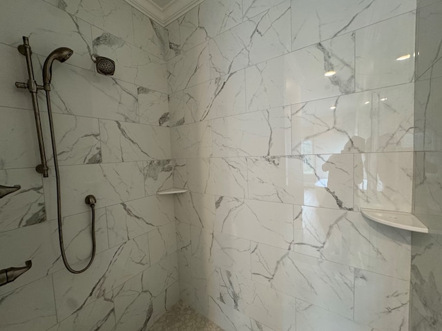 bathroom with a tile shower and crown molding