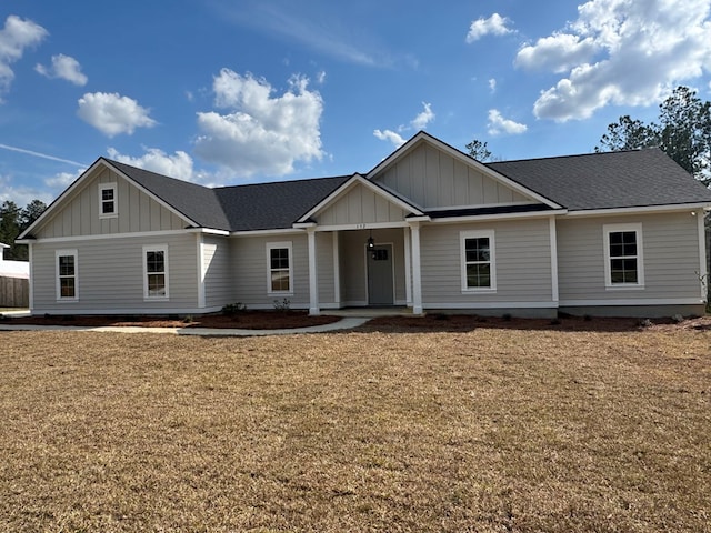 view of front of house featuring roof with shingles, board and batten siding, and a front yard