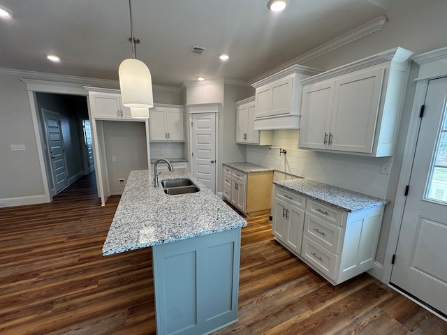 kitchen featuring visible vents, light stone counters, dark wood-style flooring, crown molding, and a sink