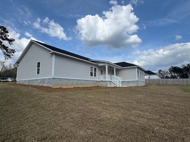 view of front of home featuring ceiling fan, a front lawn, and fence