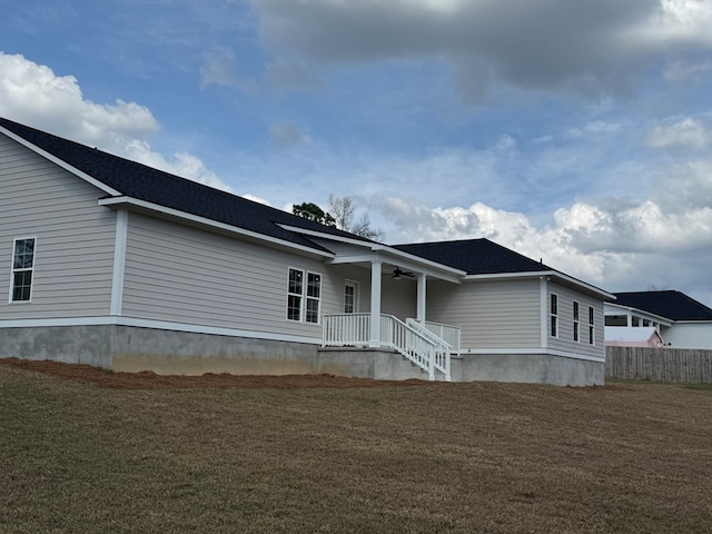 view of front of property featuring ceiling fan, a front lawn, and fence