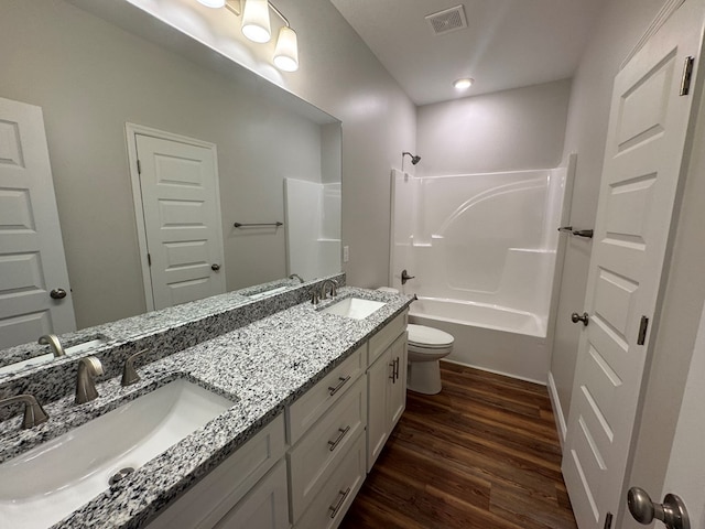 full bathroom featuring visible vents, a sink, toilet, and wood finished floors