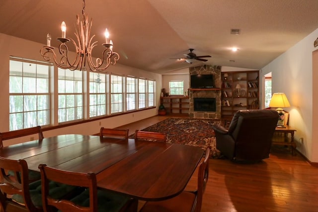 407 Lakeshore Dr, Bainbridge, GA 39819 - dining space featuring wood-type flooring, a stone fireplace, ceiling fan with notable chandelier, lofted ceiling, and visible vents