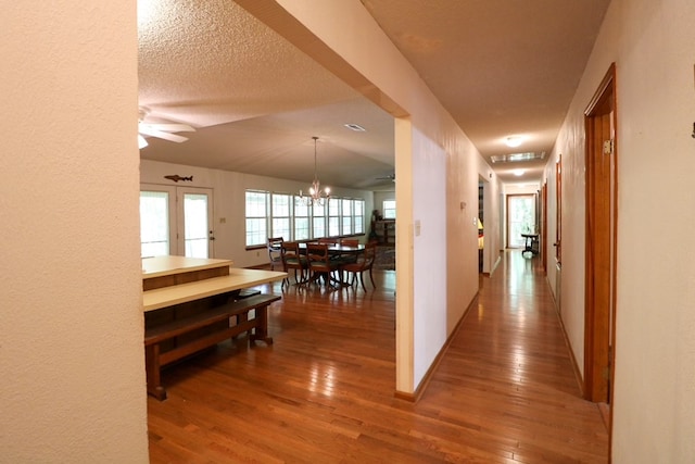 407 Lakeshore Dr, Bainbridge, GA 39819 - hallway with a textured ceiling, wood finished floors, and a chandelier