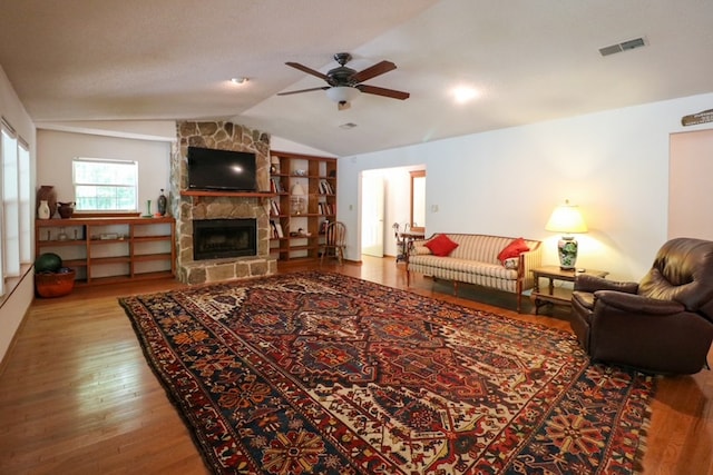 407 Lakeshore Dr, Bainbridge, GA 39819 - living area with a ceiling fan, a stone fireplace, visible vents, vaulted ceiling, and wood finished floors