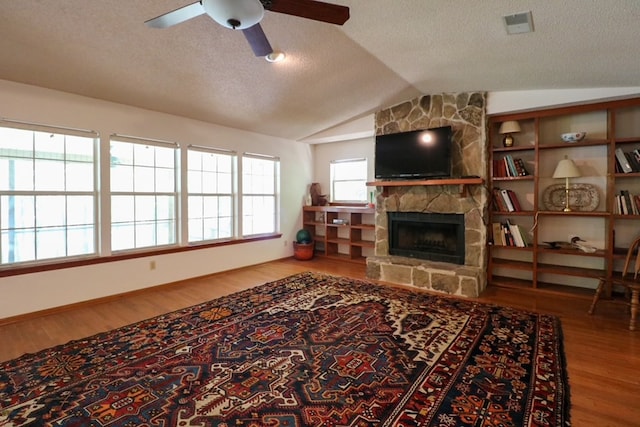 407 Lakeshore Dr, Bainbridge, GA 39819 - living area with a ceiling fan, a stone fireplace, a textured ceiling, wood finished floors, and lofted ceiling