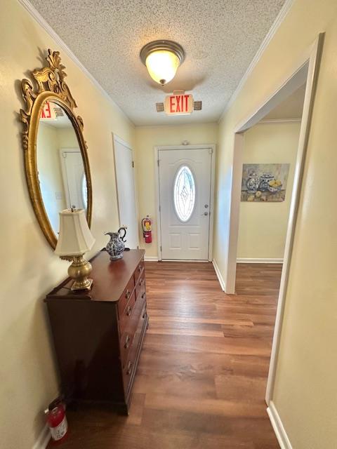 foyer featuring crown molding, wood-type flooring, and a textured ceiling