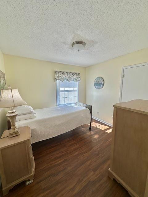 bedroom featuring dark wood-type flooring and a textured ceiling