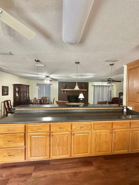 kitchen with hanging light fixtures, dark hardwood / wood-style floors, and a textured ceiling