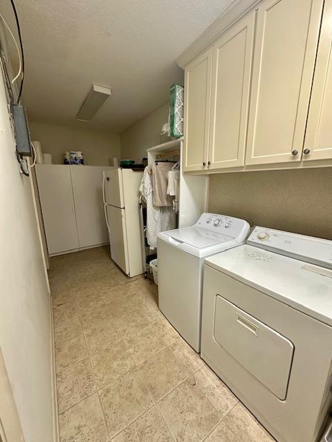 laundry area with cabinets and washing machine and clothes dryer