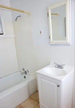 bathroom featuring tile patterned floors, vanity, and washtub / shower combination