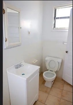 bathroom featuring tile patterned floors, vanity, and toilet