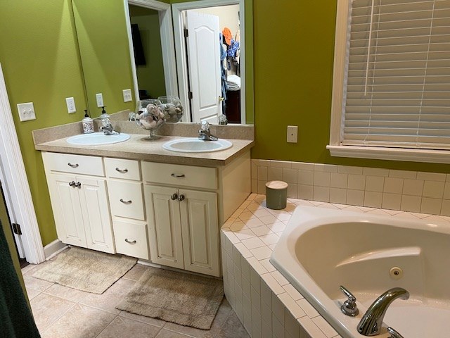 1002 Willis St, Bainbridge, GA 39819 - bathroom with double vanity, a jetted tub, and tile patterned floors