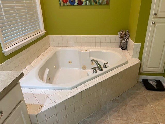 1002 Willis St, Bainbridge, GA 39819 - bathroom featuring a jetted tub, vanity, and tile patterned flooring
