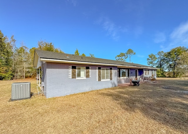 ranch-style house featuring a front yard and central AC unit