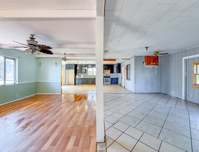 unfurnished living room featuring ceiling fan and light tile patterned floors