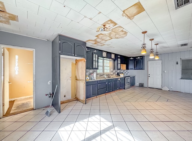 kitchen featuring decorative light fixtures, blue cabinets, stainless steel range with electric stovetop, and light tile patterned floors