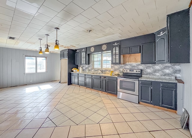 kitchen with stainless steel electric range, light tile patterned floors, hanging light fixtures, and plenty of natural light