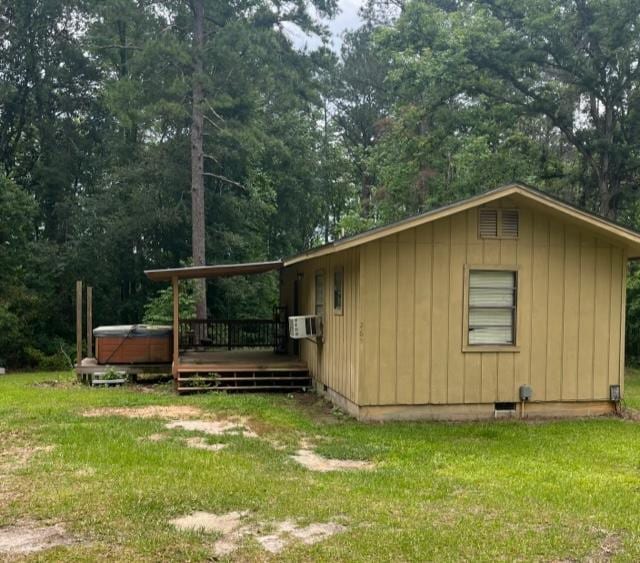 267 Providence Rd, Whigham, GA 39897 - view of side of home featuring a hot tub, a wooden deck, a yard, and board and batten siding
