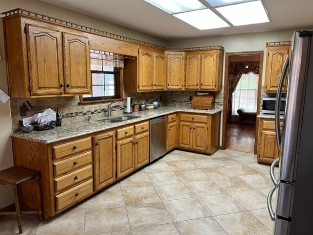 267 Providence Rd, Whigham, GA 39897 - kitchen featuring appliances with stainless steel finishes, brown cabinets, and backsplash