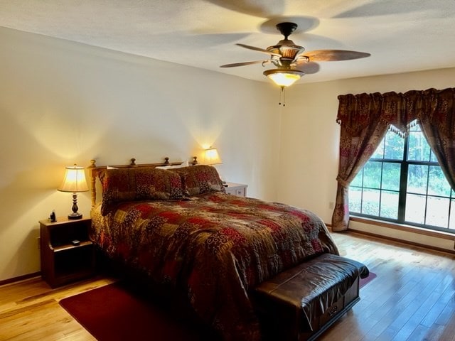 bedroom with ceiling fan and light hardwood / wood-style floors