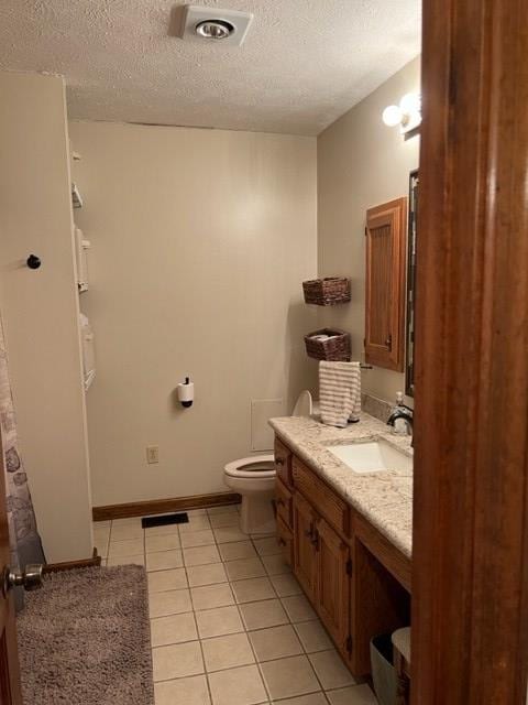 267 Providence Rd, Whigham, GA 39897 - bathroom with a textured ceiling, vanity, tile patterned floors, toilet, and baseboards