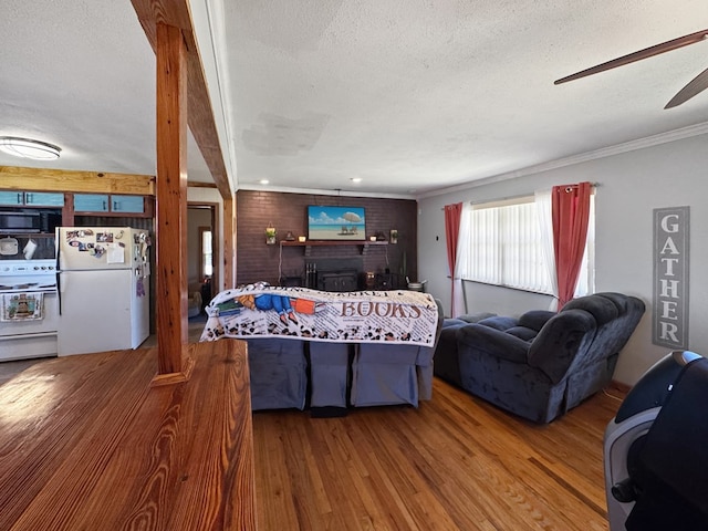 810 Three Notch Rd, Colquitt, GA 39837 - living room featuring ornamental molding, a textured ceiling, wood finished floors, a fireplace, and ceiling fan