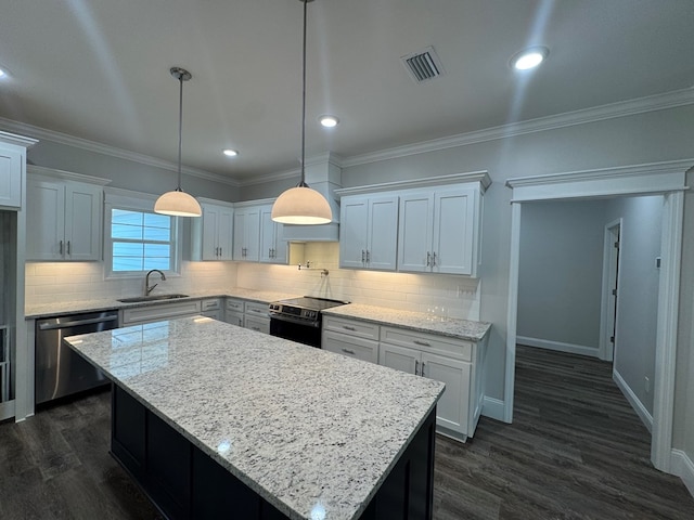 kitchen featuring a sink, visible vents, ornamental molding, appliances with stainless steel finishes, and dark wood finished floors