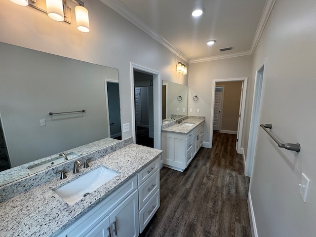 full bathroom featuring ornamental molding, two vanities, and a sink