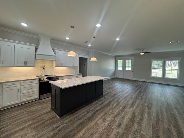 kitchen featuring crown molding, electric stove, custom range hood, and a kitchen island