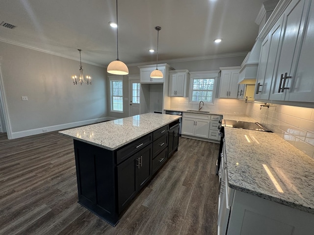 kitchen with ornamental molding, dark wood-type flooring, dark cabinets, and tasteful backsplash