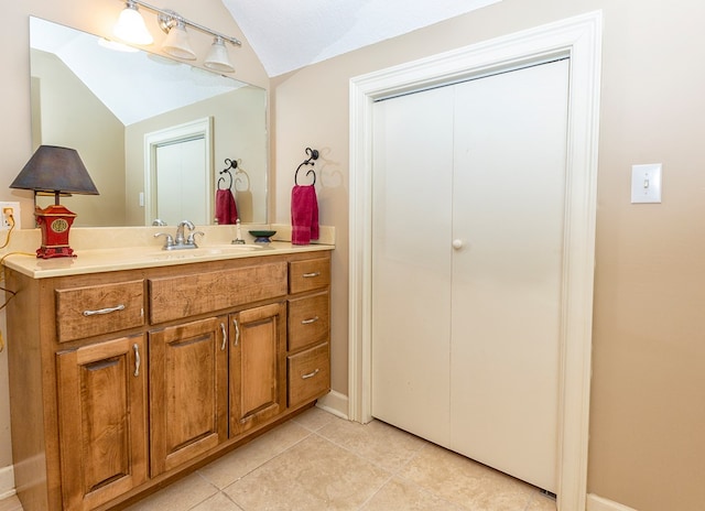 bathroom featuring tile patterned floors, vanity, lofted ceiling, and a textured ceiling