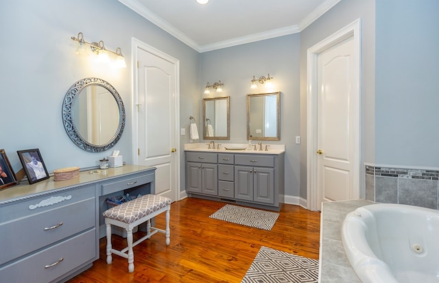 bathroom with vanity, ornamental molding, a relaxing tiled tub, and hardwood / wood-style flooring