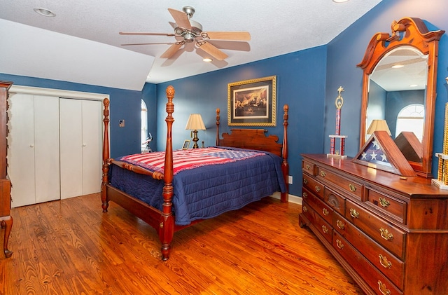 bedroom featuring hardwood / wood-style floors, ceiling fan, a textured ceiling, and a closet