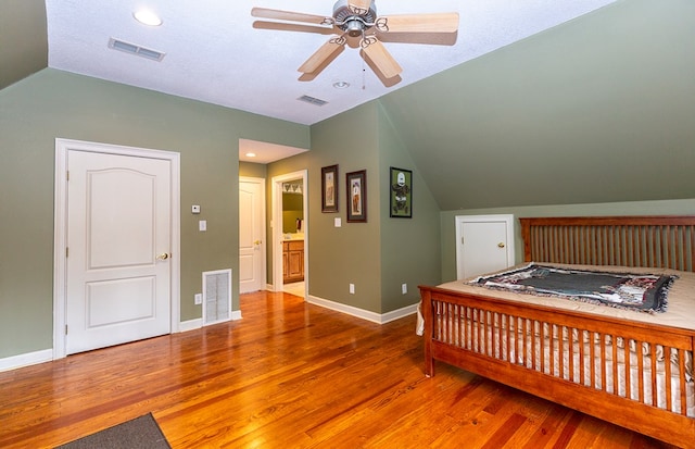 bedroom with lofted ceiling, ceiling fan, wood-type flooring, and a textured ceiling