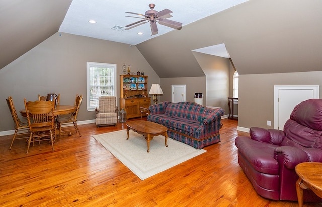 living room with ceiling fan, vaulted ceiling, and light hardwood / wood-style flooring