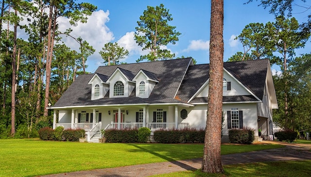 cape cod home featuring covered porch and a front lawn