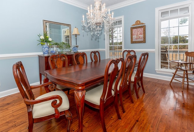 dining space with hardwood / wood-style flooring, plenty of natural light, crown molding, and a chandelier