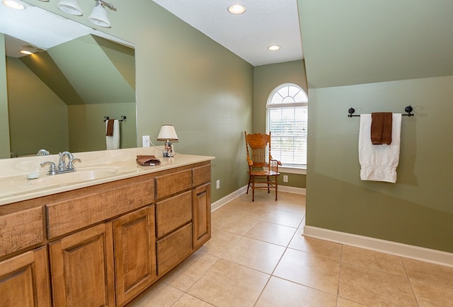 bathroom with tile patterned floors, vanity, and vaulted ceiling