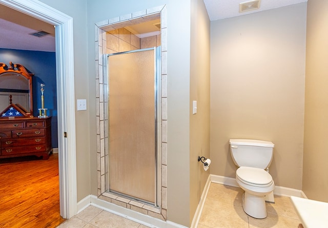 bathroom with a shower with door, wood-type flooring, and toilet