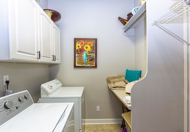 washroom featuring washer and dryer, cabinets, and light tile patterned floors