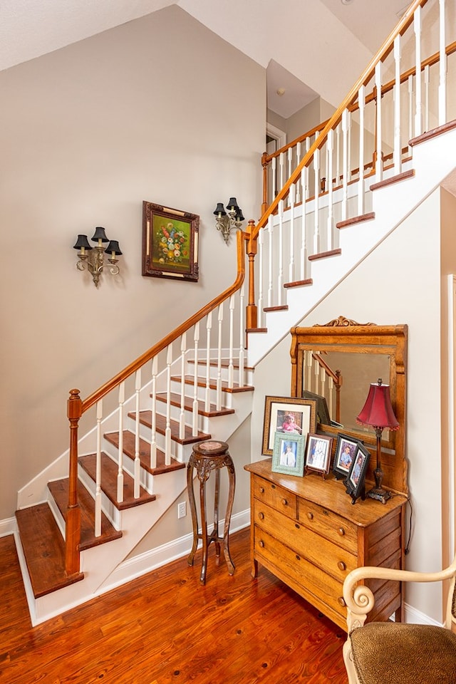 stairway featuring hardwood / wood-style floors and vaulted ceiling