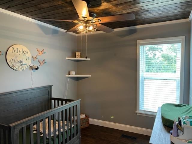 1104 Old Thomasville Rd, Cairo, GA 39828 - bedroom with wooden ceiling, crown molding, dark wood-style floors, a crib, and ceiling fan