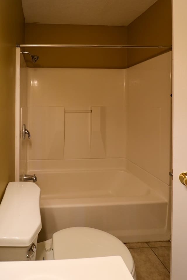 bathroom featuring tile patterned floors, shower / bathing tub combination, and toilet