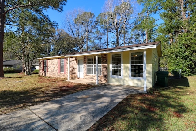 view of front of home with brick siding, covered porch, and a front lawn