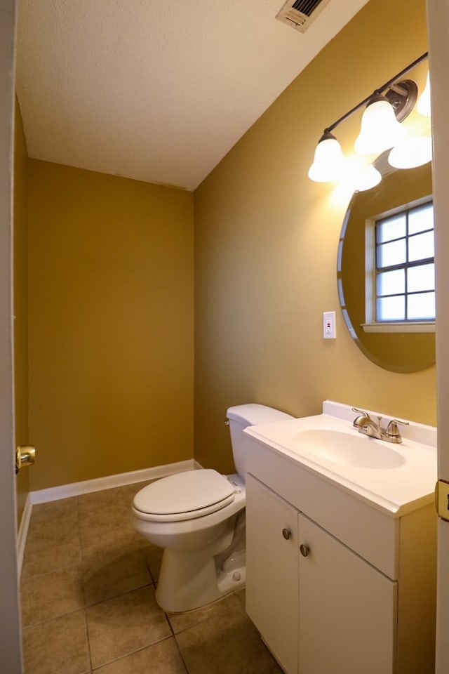 bathroom featuring vanity, visible vents, baseboards, tile patterned flooring, and toilet