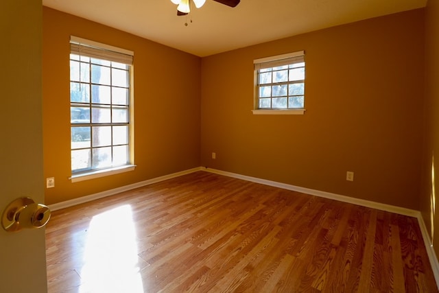 empty room with a ceiling fan, baseboards, and light wood-type flooring