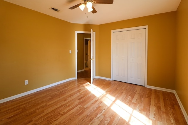 unfurnished bedroom featuring visible vents, baseboards, a closet, and light wood finished floors